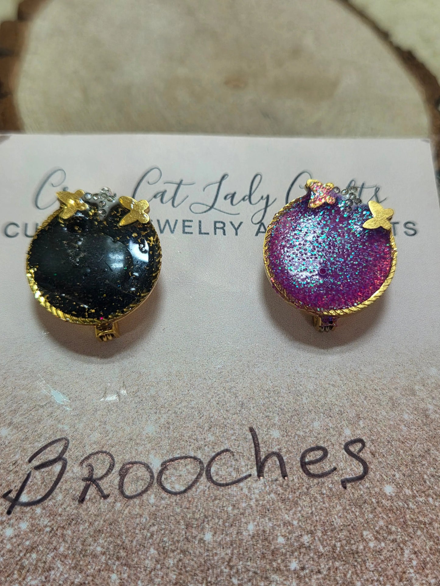 2 small round brooches one black and one pink has a gold back and small gold butterflies they also sparkle - Crazy Cat Lady Crafts