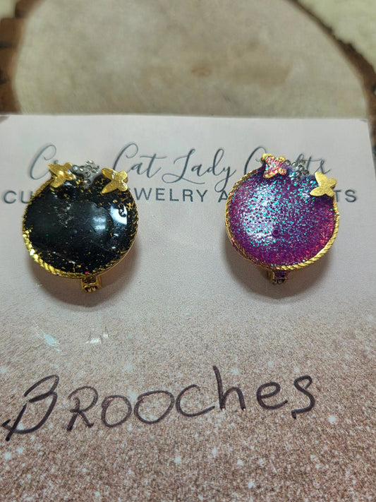 2 small round brooches one black and one pink has a gold back and small gold butterflies they also sparkle - Crazy Cat Lady Crafts
