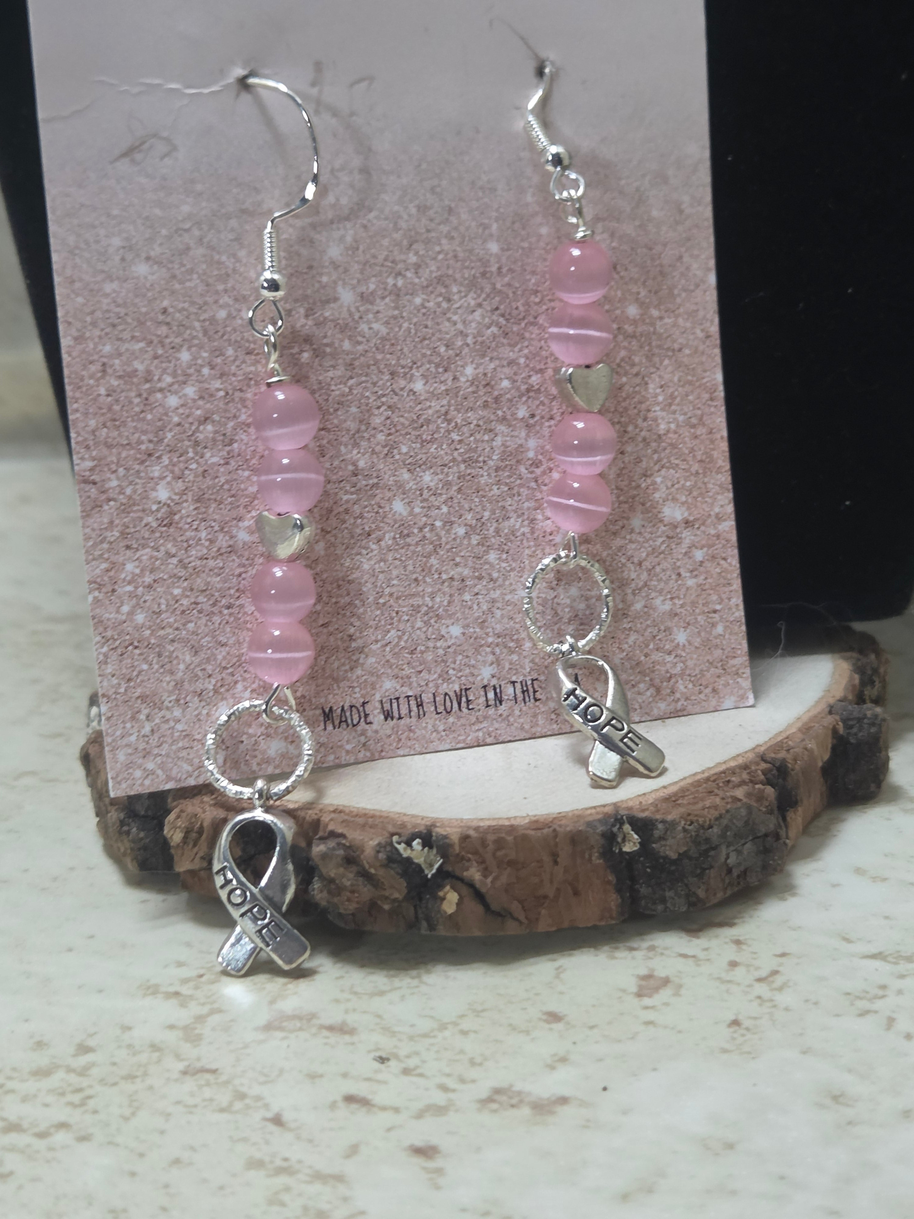 Silver and pink breast cancer earrings with silver metal charm says Hope