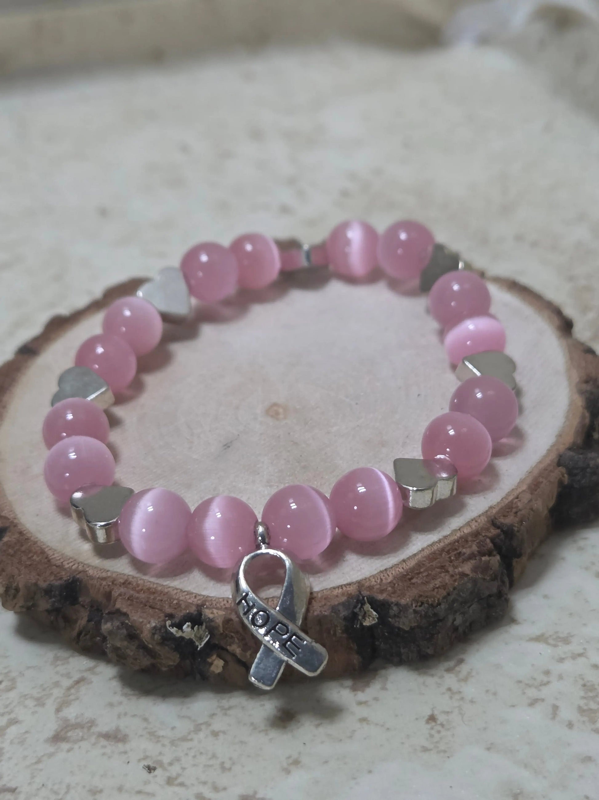 Pink cat eye beads and silver heart beads and a silver metal cancer ribbon that says Hope on the charm stretchy bracelet - Crazy Cat Lady Crafts