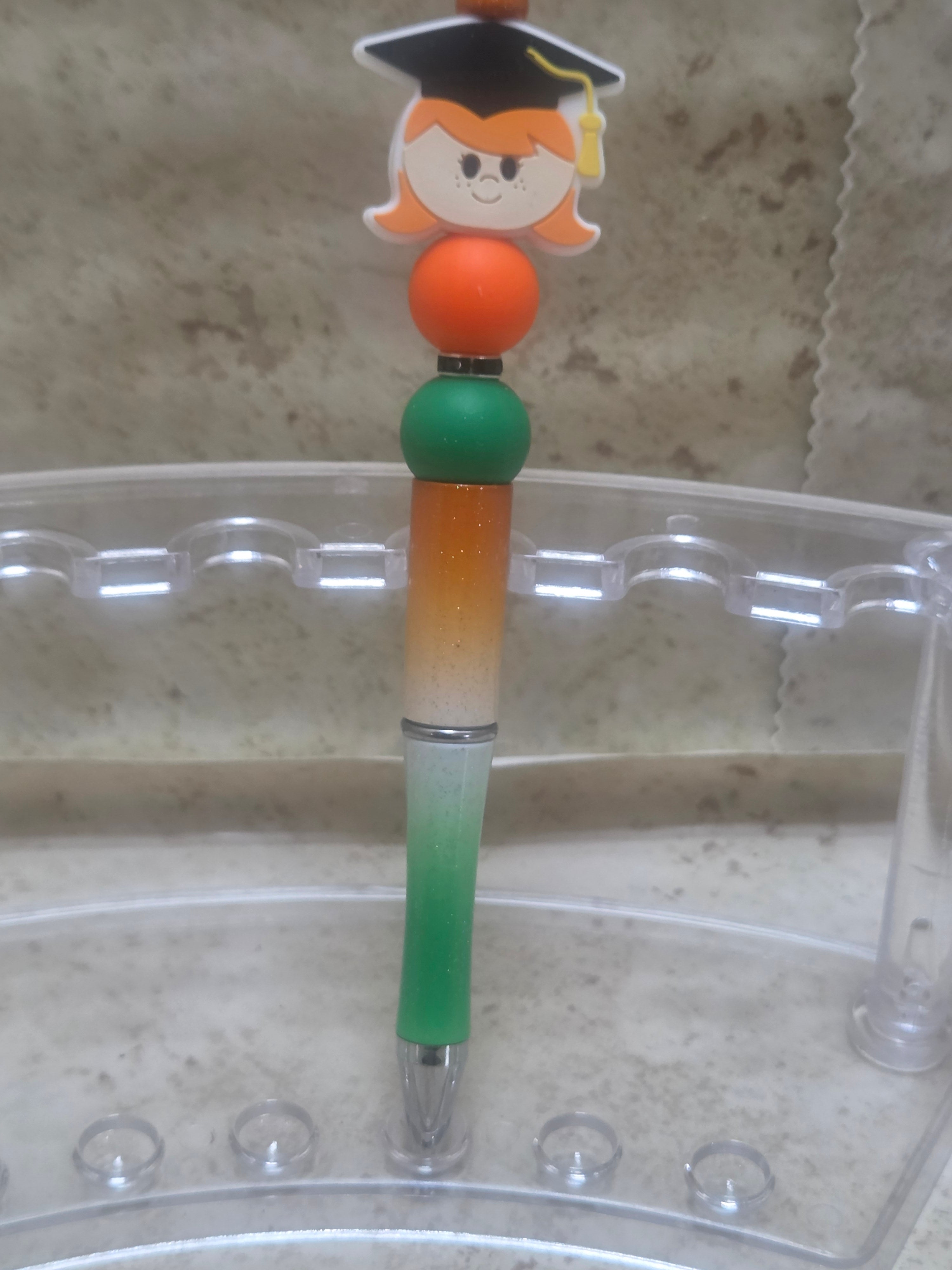 Green white and orange ombre sparkly barreled graduation pen with a girl for the top