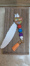 White silicone feather bookmark with a heart shaped and multi colored beads and a tassel - Crazy Cat Lady Crafts