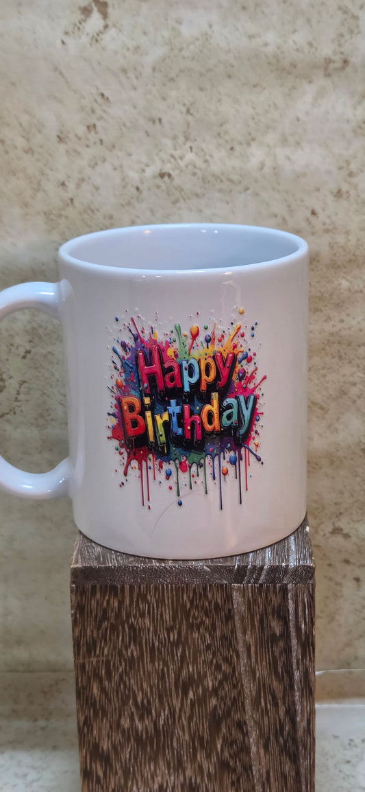11 ounce white coffee mug with colorful splashes and says happy birthday