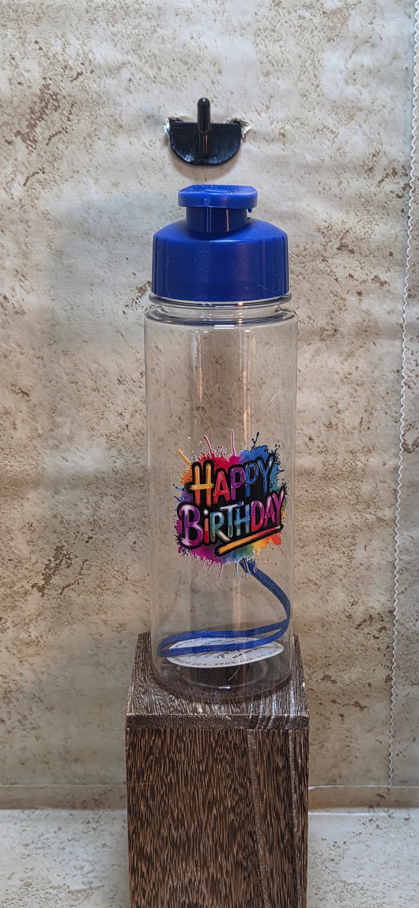 17 ounce clear water bottle with blue flip top and detachable strap that has Happy Birthday saying