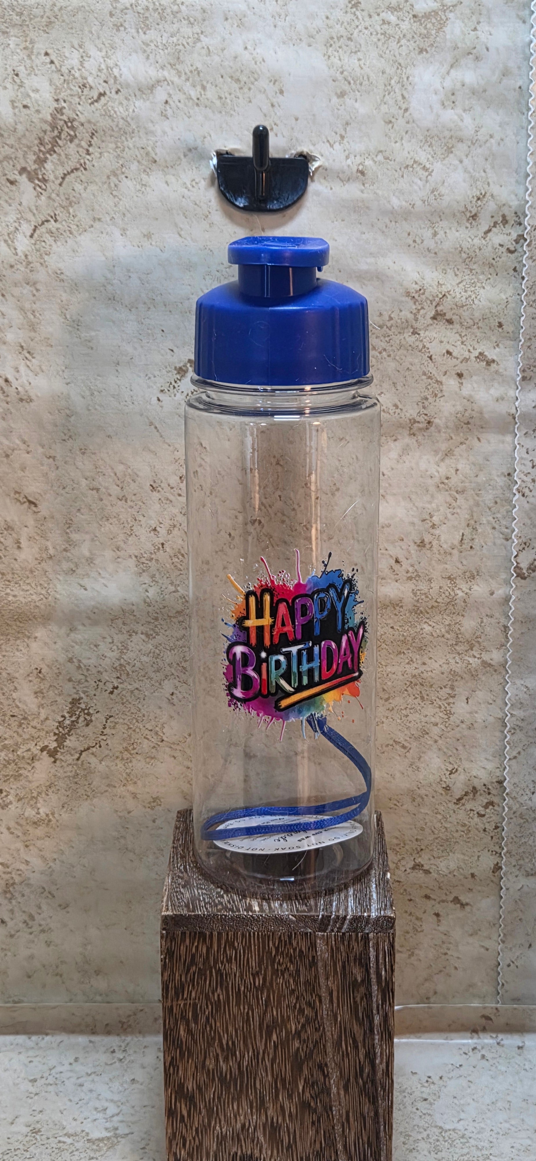 17 ounce clear water bottle with blue flip top and detachable strap that has Happy Birthday saying