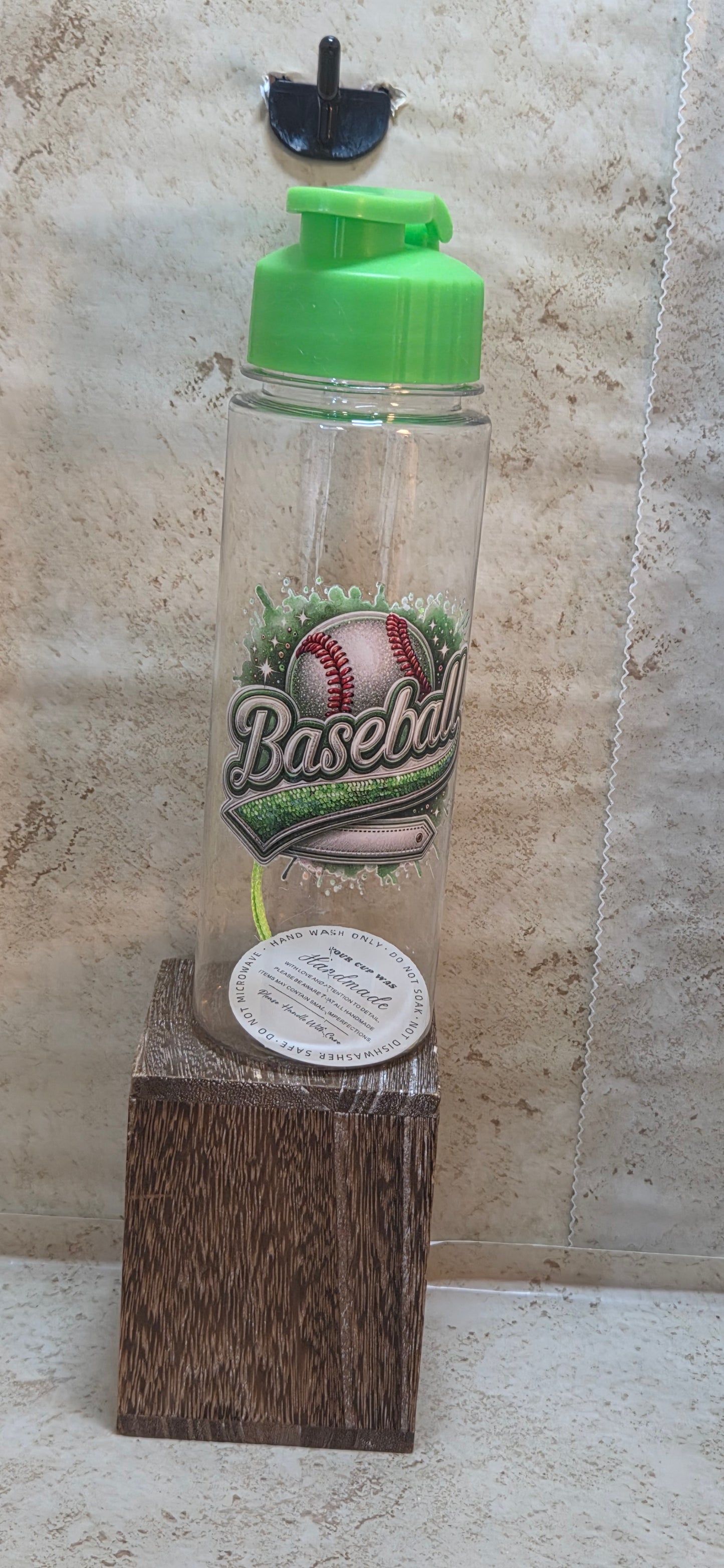 17 ounce clear water bottle with green flip top lid and strap with green baseball design