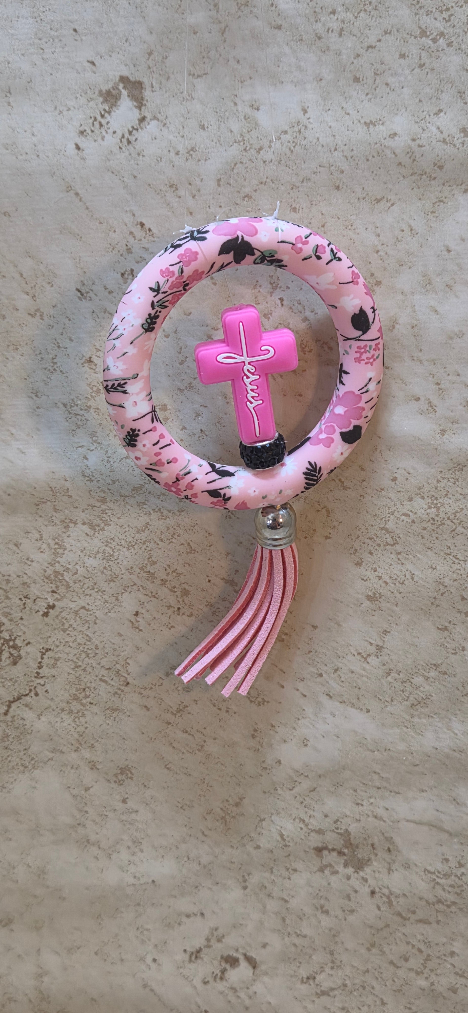 Pink floral ring with pink cross with white lettering Jesus with tassel rear view mirror ornament