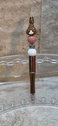 Brown poop emoji and brown an white beaded pen