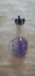 Purple see thru resin skull with hearts cut out for eyes and purple tassel keychain
