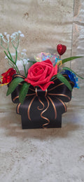Hand designed Star Spangled bouquet of foam and tin roses in red white and blue in a black and gold bow box