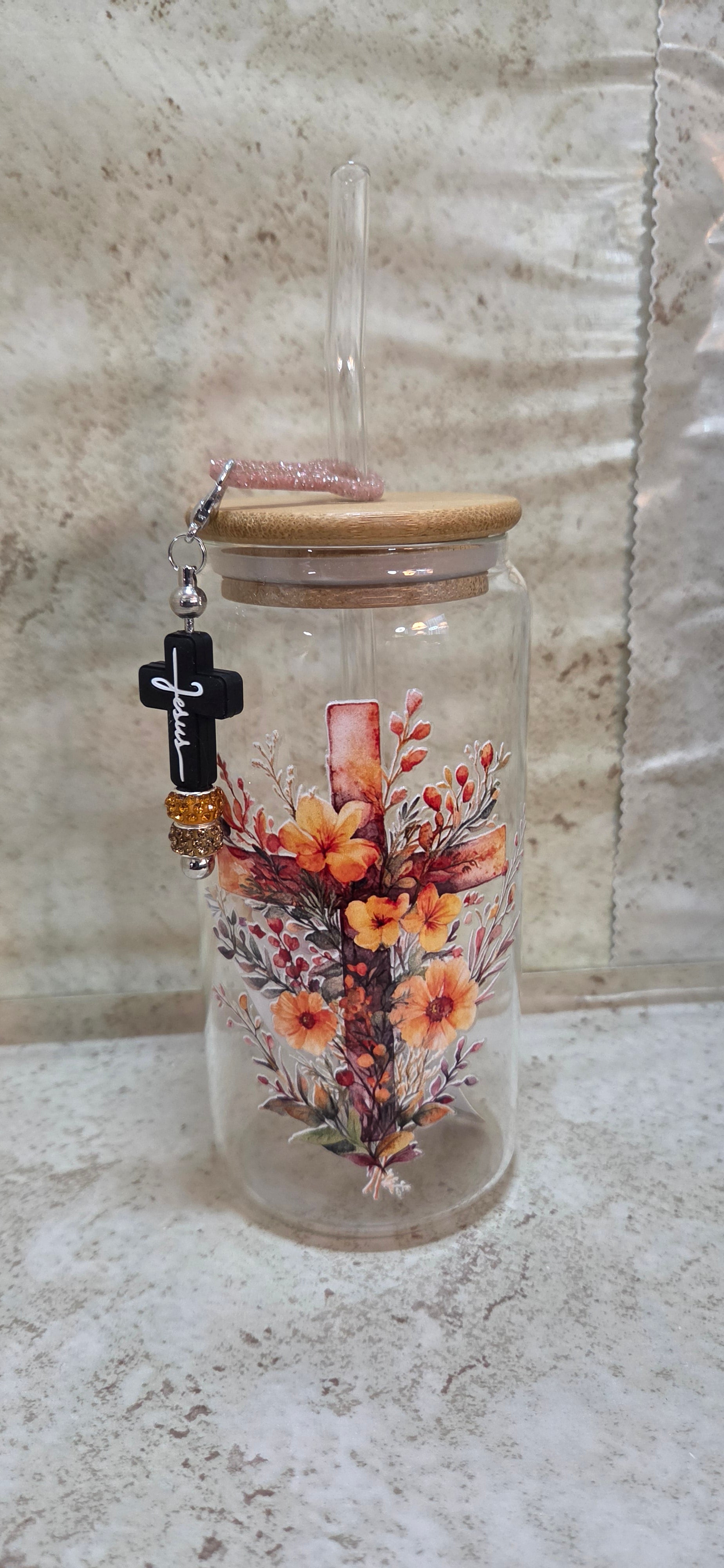 Glass tumbler with wooden top and straw with a cross and fall flowers design and straw charm with black cross and sparkly beads