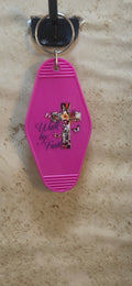 Pink replica of a motel keychain with a floral designed cross and butterflies says Walk by Faith