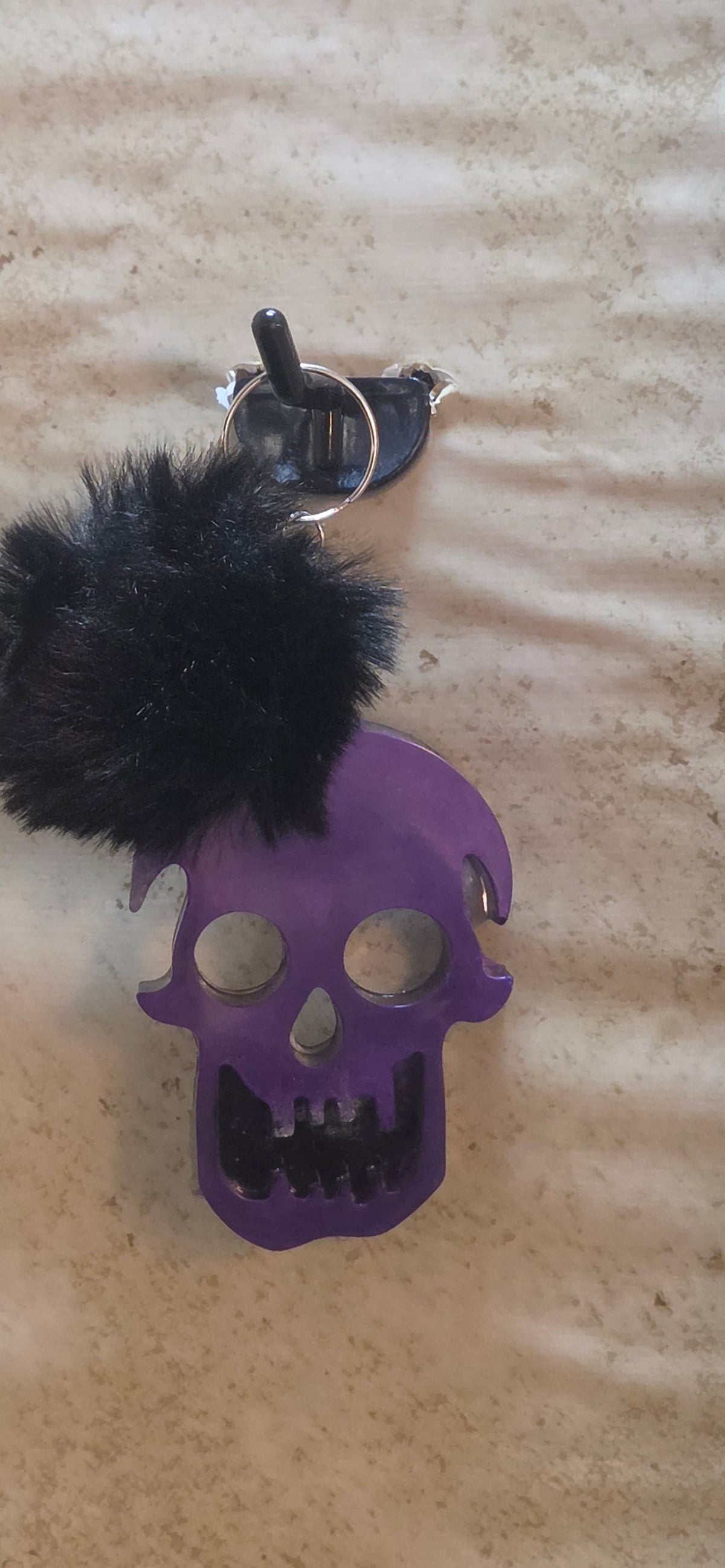 Scary 3 inch skull keychain in purple and black with black pompom