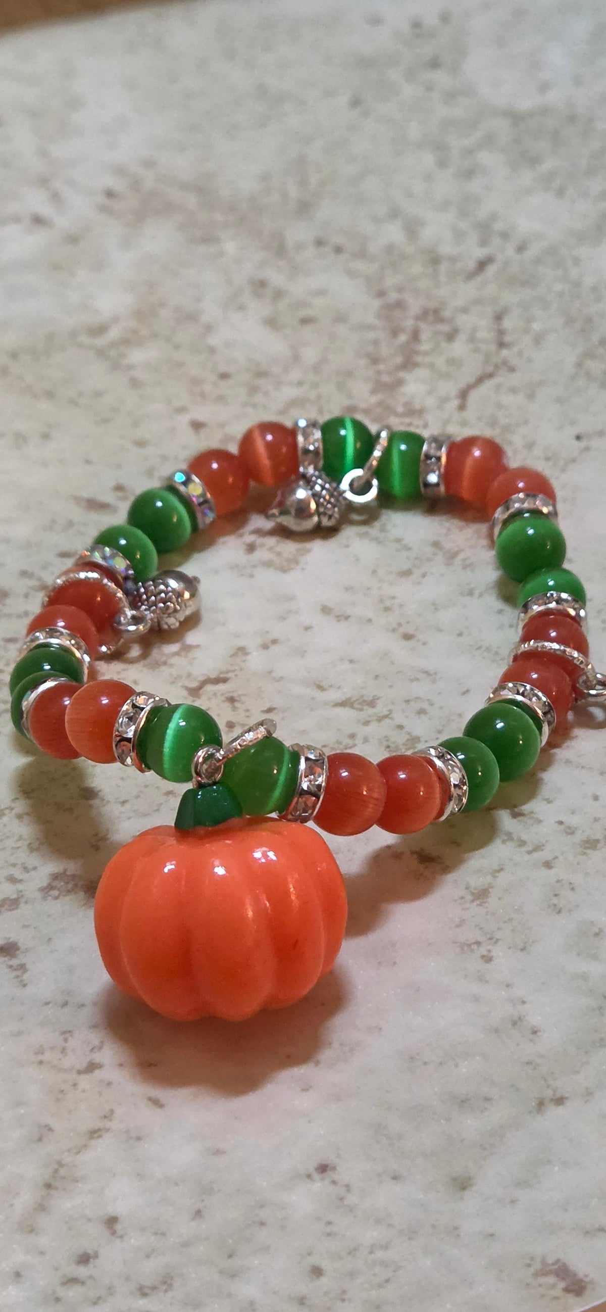 Size 7.5 stretchy bracelet  in green and orange and a pumpkin
