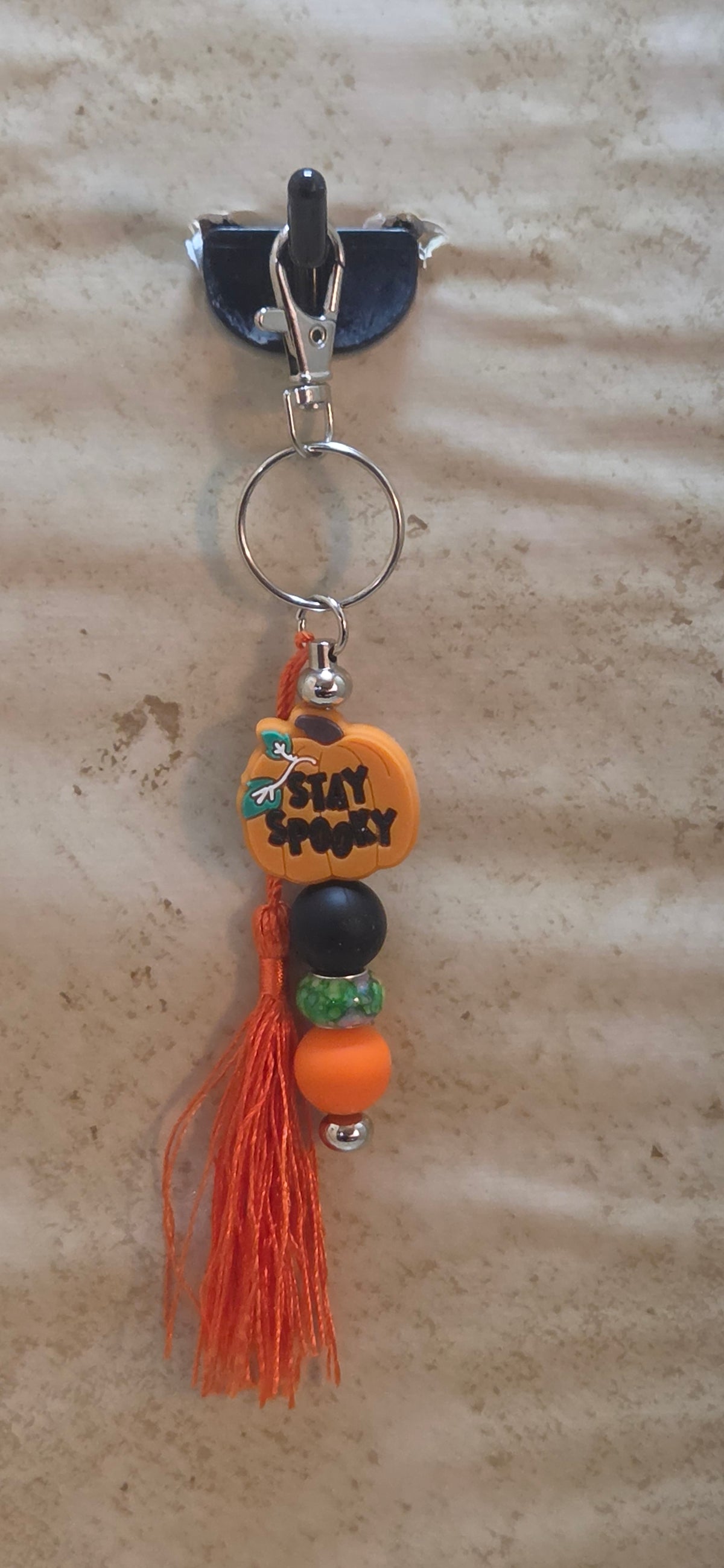 A Halloween bag tag with a pumpkin that say stay spooky