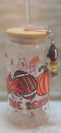 16 oz glass tumbler with a football pmpkin and leaf design with a football charm