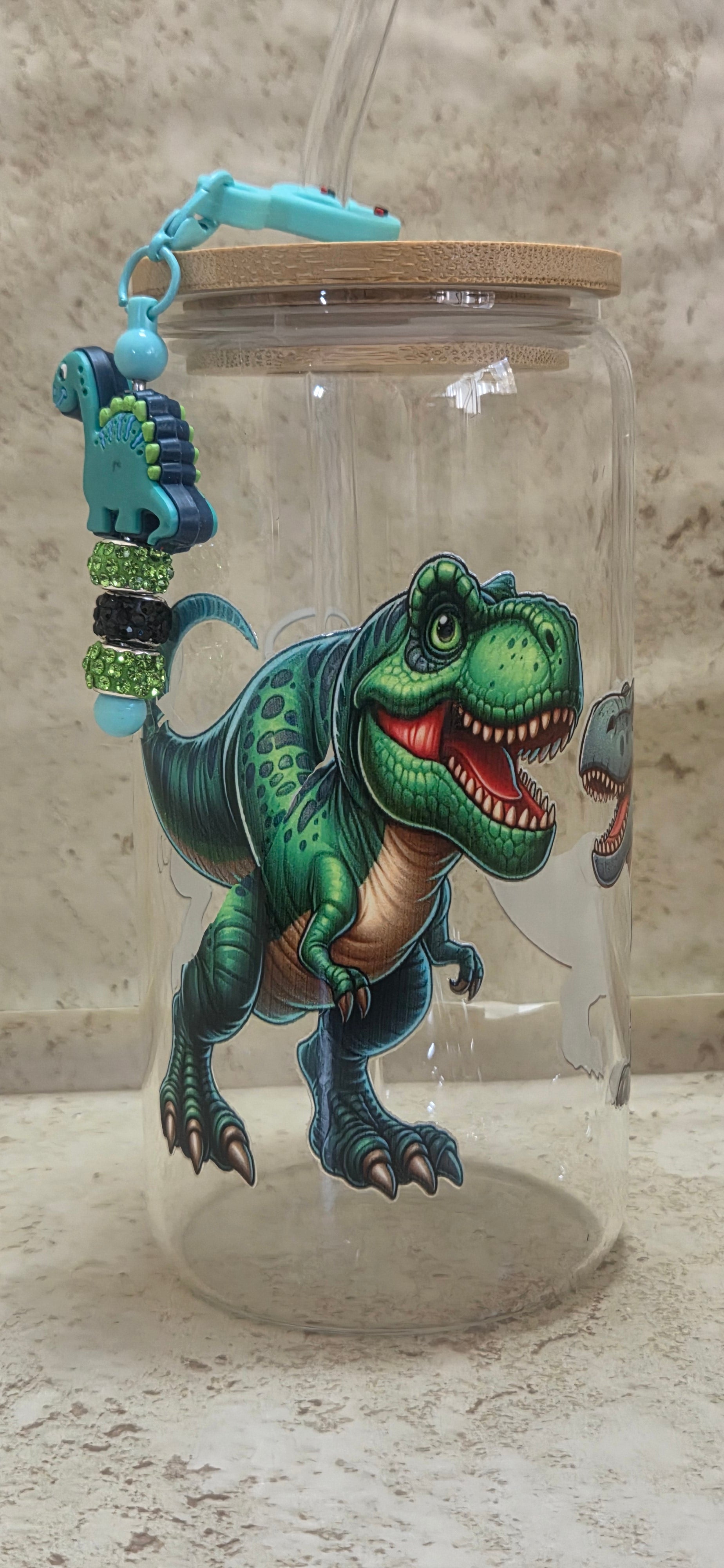 16 oz glass tumbler with green dinosaur design and dinosaur charm